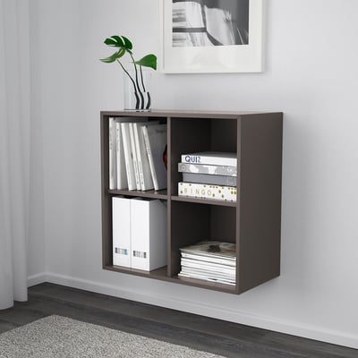 A wall-mounted EKET storage cabinet. It holds books, games, and a vase on its shelves. The cabinet is efficient for space-saving and organisation.