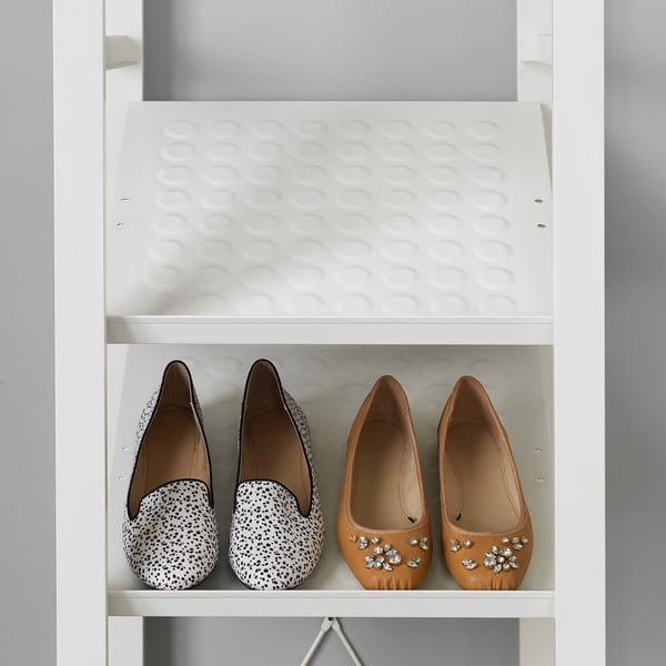 White closet with shoe shelf holding two pairs of shoes, one black and white, one brown with rhinestones, display for organised storage.