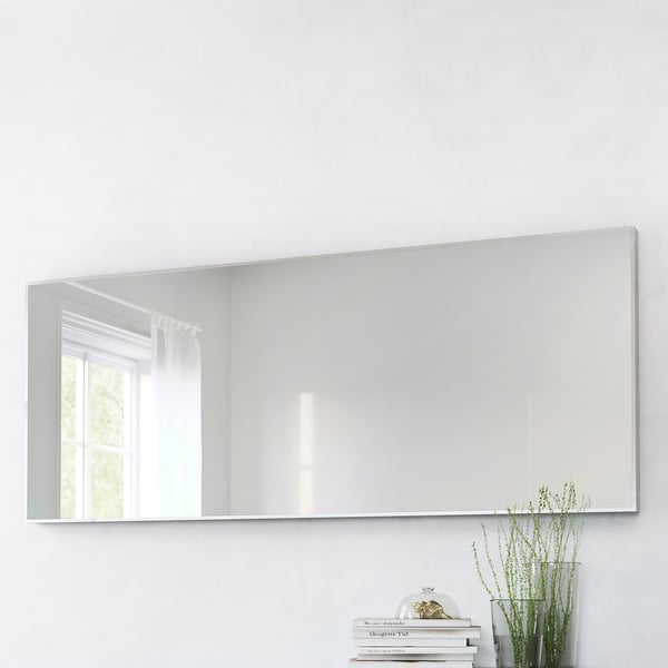 Large rectangular mirror, mounted vertically, reflects window and room. Place near a plant and books for a cosy, organised look. Safety film included.