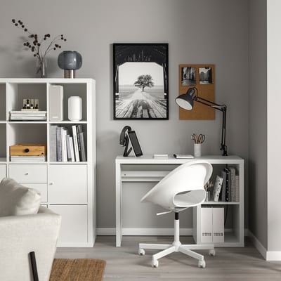 Modern home office with KALLAX desk, rolling chair, and minimalist decor.