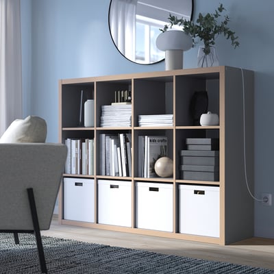 KALLAX shelf in living room with books, decor, mirror.