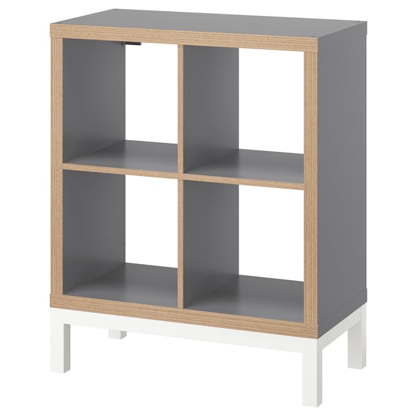 The KALLAX shelf is grey with white legs, rectangular, and modular-designed. Made of particleboard, steel, and foiled edges.