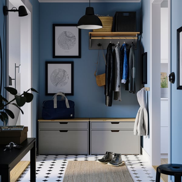 Modern blue hallway with KALLSÖ grey storage bench, hanging coats, and wall art. Bench fits narrow spaces, with drawers for storage.