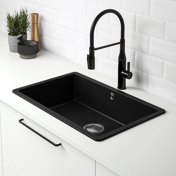 Black KILSVIKEN quartz sink with a pull-down tap, set in a white countertop against a white tiled backsplash.