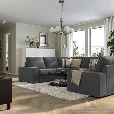Modern living room with KIVIK grey sofa, white sideboard, and large windows. Sofa is spacious with low armrests, ideal for relaxation.
