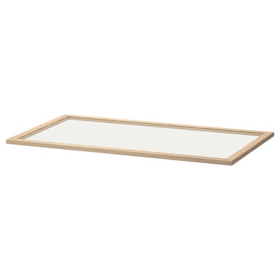 An ikea KOMPLEMENT light glass shelf in clear. It has a light wooden frame and a transparent glass surface.