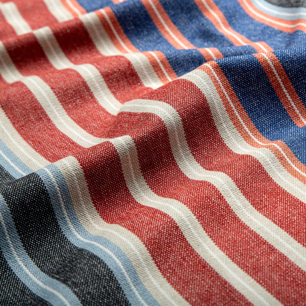 Close-up of textured, striped fabric; vivid red, blue, and white stripes showcase quality and detail.