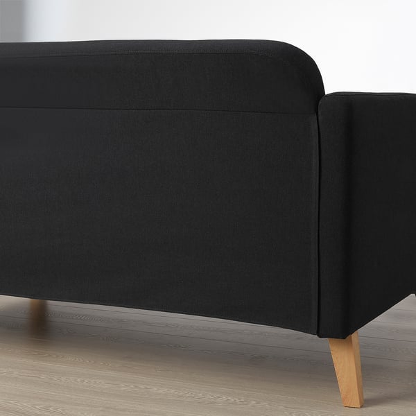 Black sofa with wooden legs. Part of the LINANÄS collection.