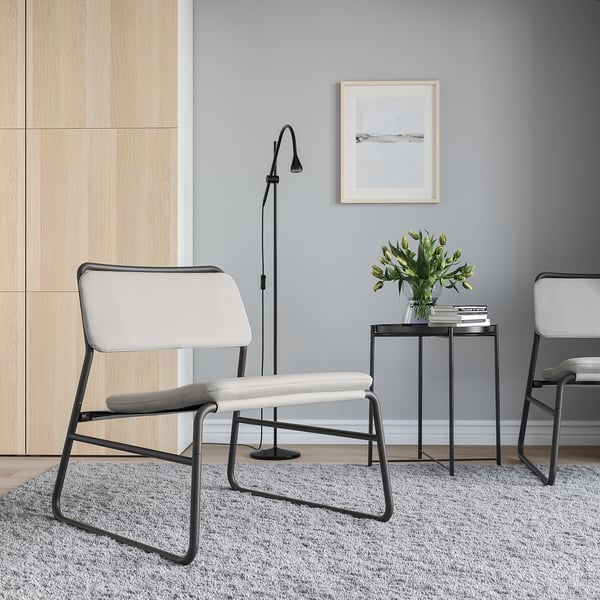 Modern living room with LINNEBÄCK chairs, side table, rug, lamp, and artwork.