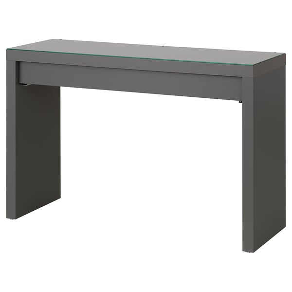 A grey MALM dressing table by IKEA, featuring a glass top, a single drawer with a felt lining, and sturdy legs.