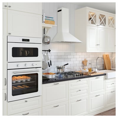 Modern kitchen with white cabinets, built-in oven, microwave, gas stove, and utensils.