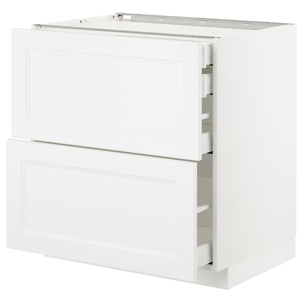 White METOD kitchen unit with closed and open drawers, sleek modern design.