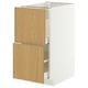 White METOD cabinet with light oak drawers and metallic handles, perfect for kitchen storage.