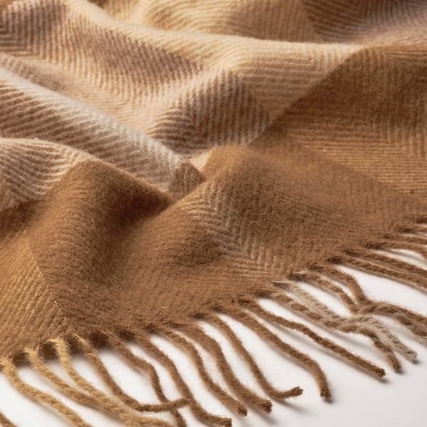 Beautifully woven wool throw with soft, cosy texture and fringe, light brown colour.