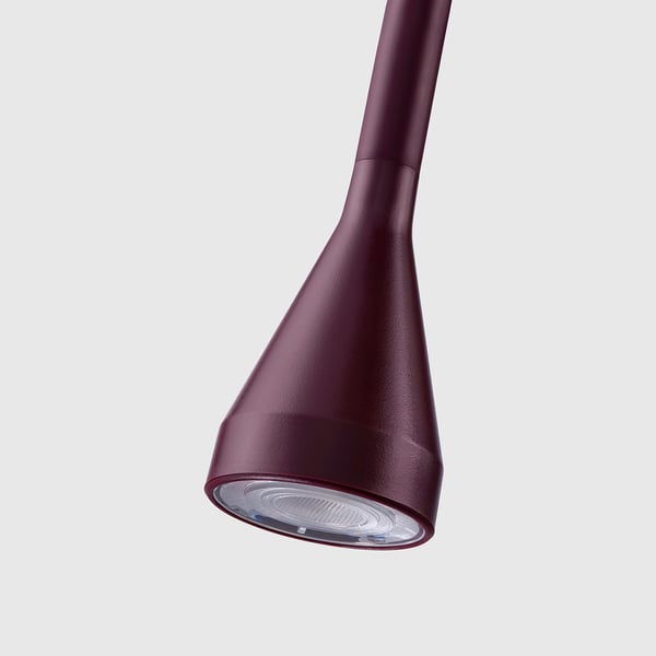 A sleek, modern, burgundy lamp with an adjustable neck and a focused light source.