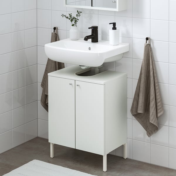 White NYSJÖN vanity with sink, silver handles, black tap, grey towels nearby, compact yet spacious.
