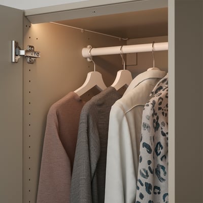 A wardrobe with led lights inside, illuminating clothes on hangers.