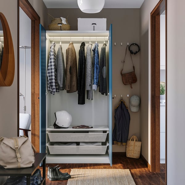 Open wardrobe displaying clothes, helmet, and bags; showcasing PAXs organisers and adjustable.