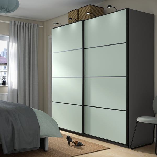 Modern bedroom with sleek, spacer light blue PAX wardrobe, mirrored doors, and built-in lights.