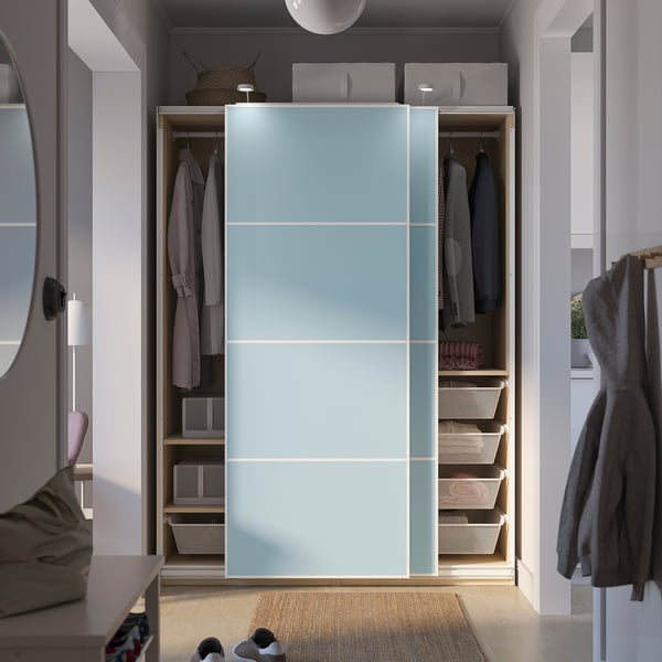 Modern closet with sliding doors and interior organisers, featuring hanging shelves and baskets for clothes storage.