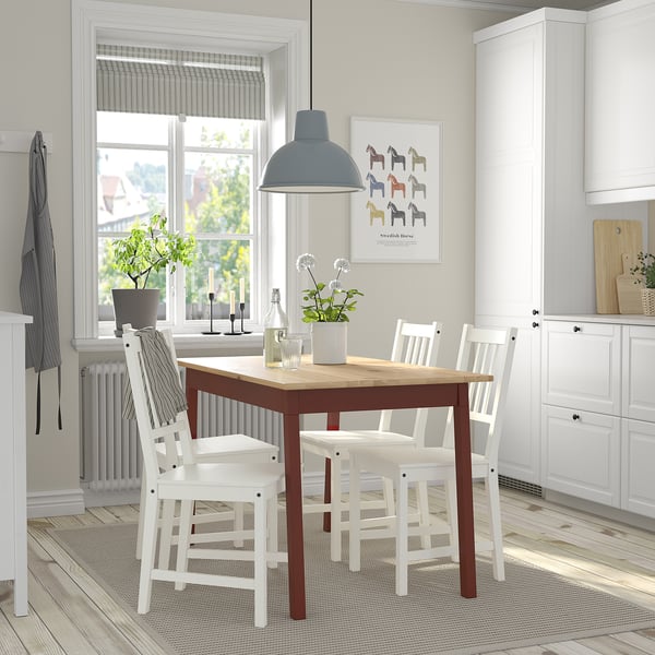 Small, brown PINNTORP dining table with 4 white chairs, light fixture, kitchen setting.