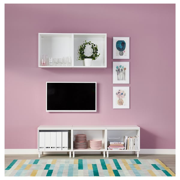 Modern living room with pink walls, white PLATSA storage unit, flat screen tv, colourful rug, and decorative artwork.