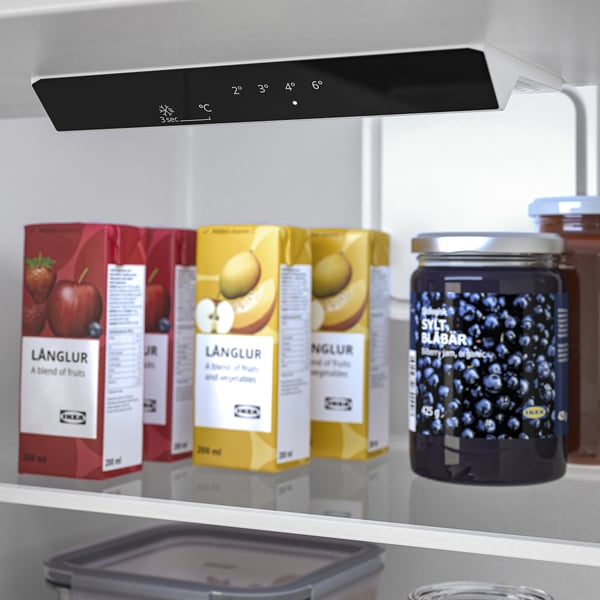 Fridge interior with lit control panel, juice cartons, blueberries, and honey jar.