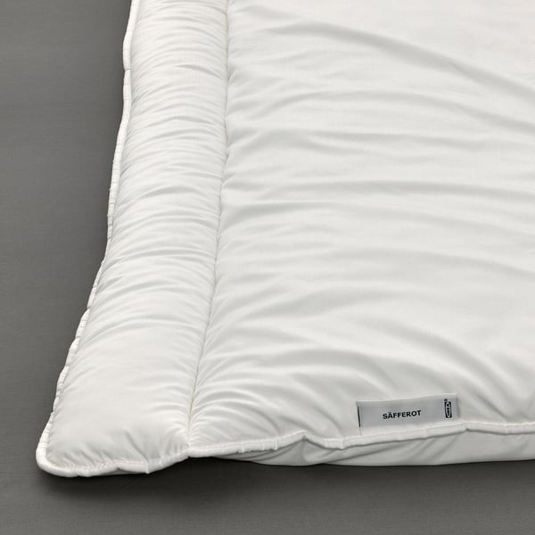 White SÄFFEROT duvet on bed, showing soft, lightweight, and durable design with recycled materials.