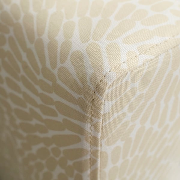 Close-up of a sofas corner, showcasing its sturdy stitching and elegant, patterned fabric.