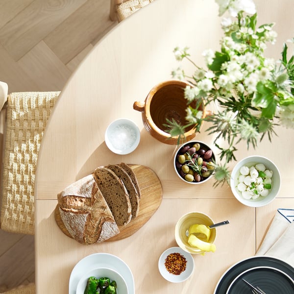 SKANSNÄS round dining table with food & flowers.
