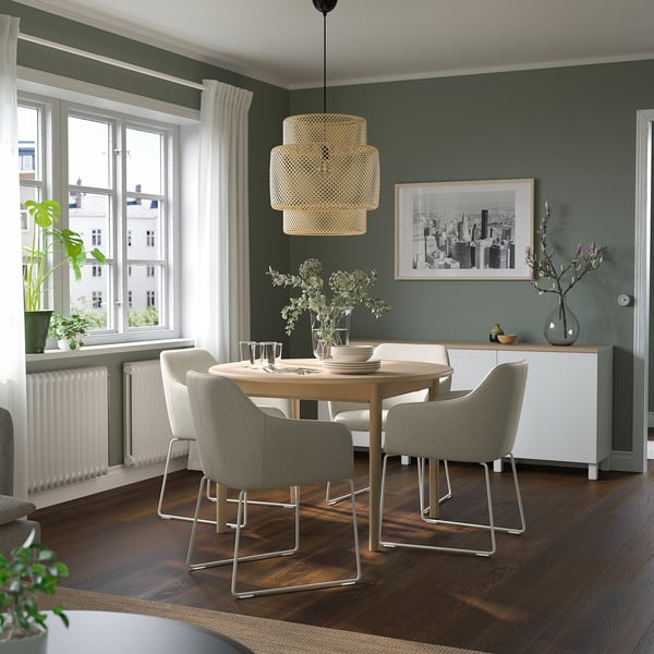 Modern dining set with light wood table and grey chairs, large window, green walls.