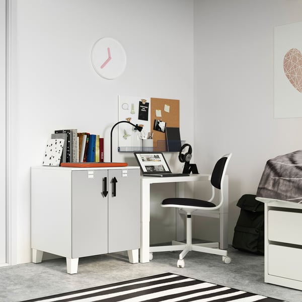 A small, white, modern study area with a desk, chair, and storage unit, perfect for a childs room.