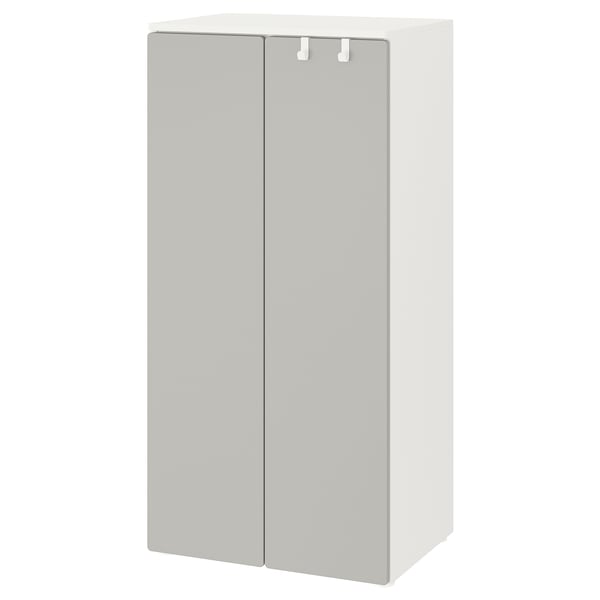 A white SMÅSTAD wardrobe with grey doors, featuring soft-close hinges and adjustable feet.
