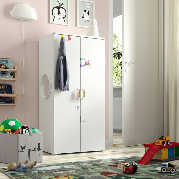 A childrens bedroom with a SMÅSTAD white wardrobe, smaller than the doorway, featuring hooks for hanging clothes.