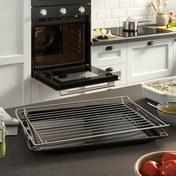 Black STENABY oven with open door and cooling rack on counter.