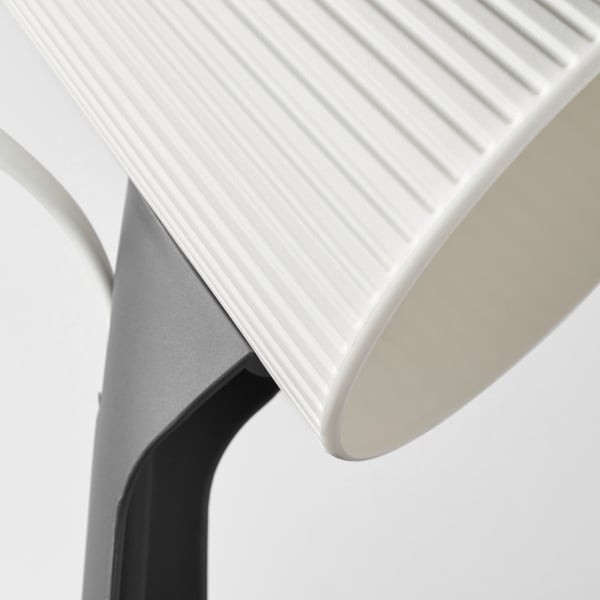 Close-up of modern, minimalist lamp with sleek, curved design and textured surface.