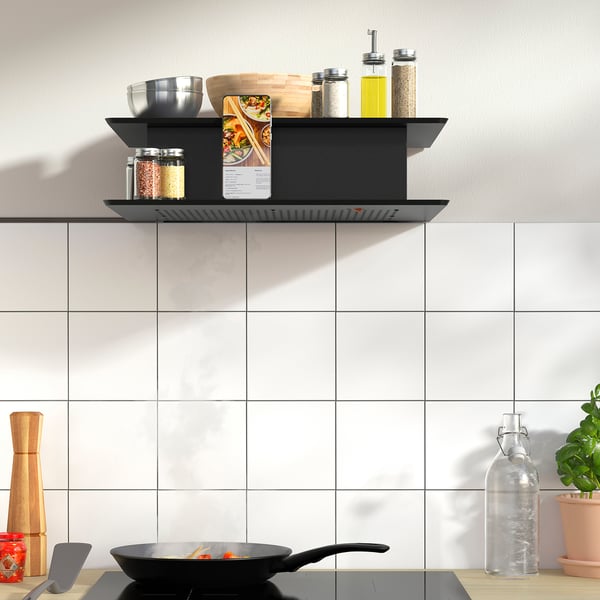 Modern kitchen with unique wall-mounted range hood displaying cooking utensils and a smartphone.