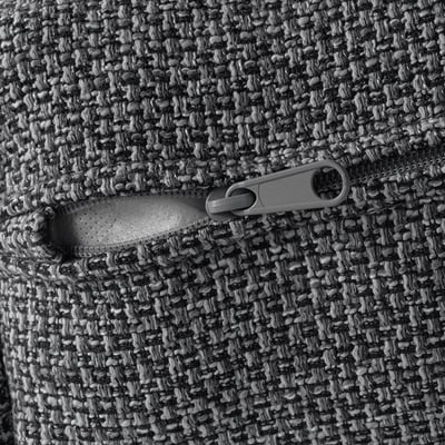 Close-up of a zip on a knitted fabric, likely from a sofa or cushion. The zip is child-safe.