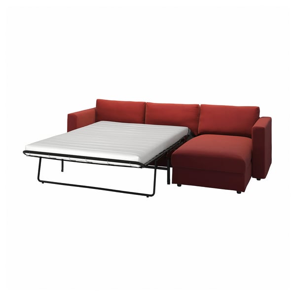 Red convertible sofa bed with white mattress, minimalist design.