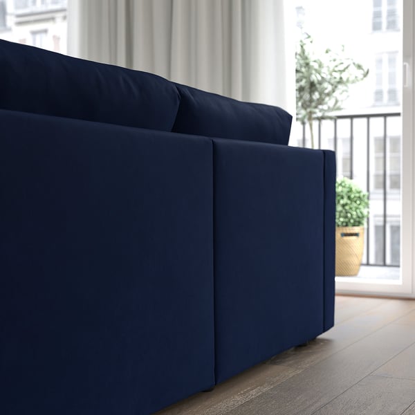 Navy blue sectional sofa by window, with potted plant nearby. Storage under seat.