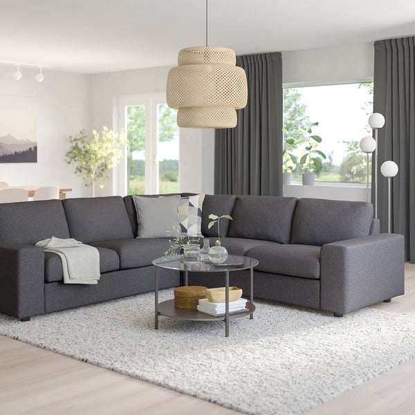 Modern grey VIMLE sectional sofa with round coffee table, light fixture, and large window.