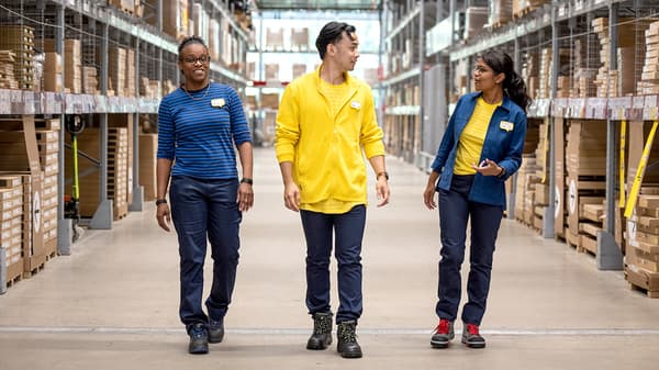 3 IKEA co-workers walking through a warehouse