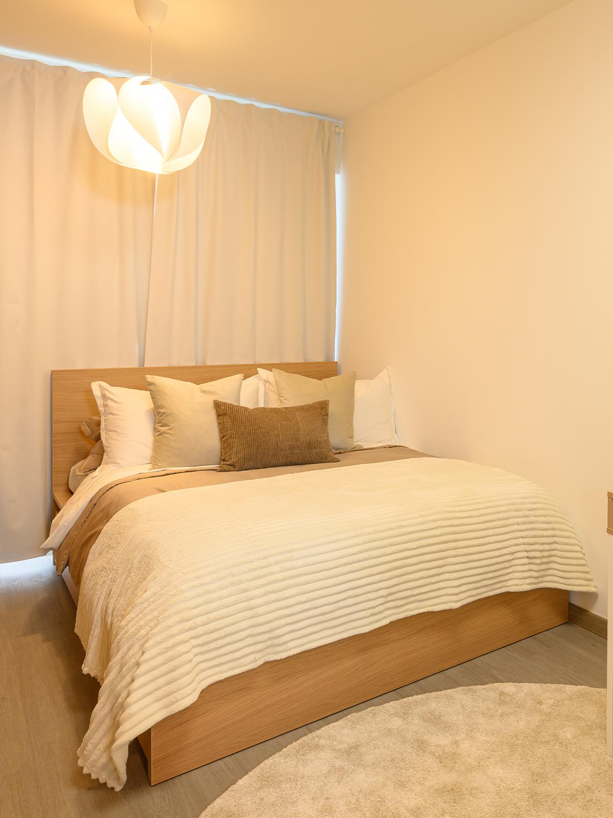 A 45 degree angle shot of homeowner's master bedroom featuring a white stained oak MALM bed.