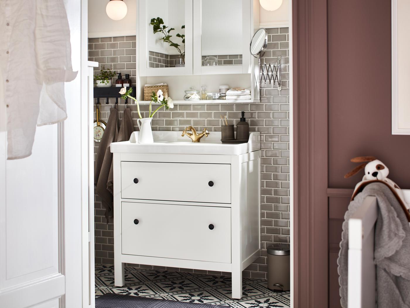 A bathroom with a HEMNES/RÄTTVIKEN washstand with two drawers in white and a HEMNES mirror cabinet with two doors in white.