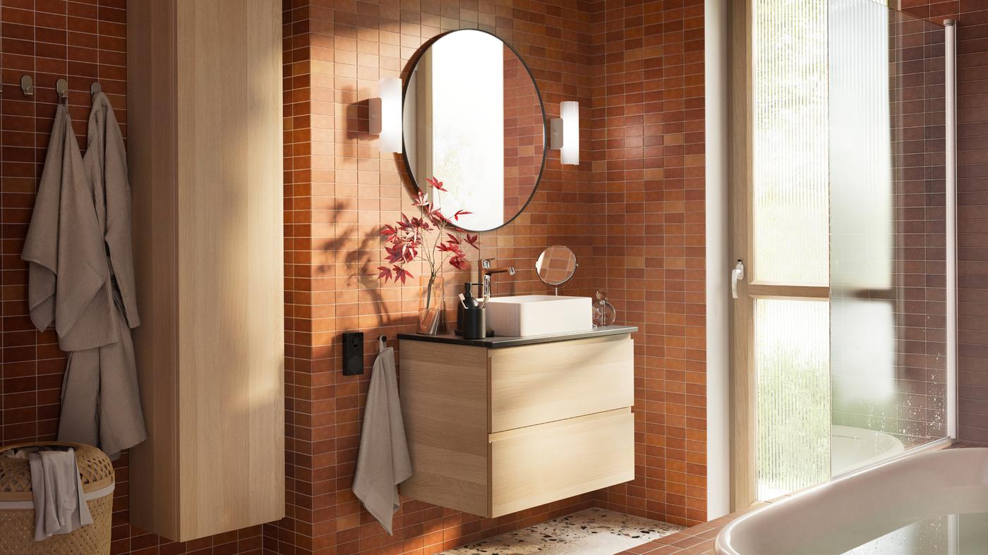 A bathroom with a TRENSUM mirror in stainless steel and a LINDBYN mirror in black and a GODMORGON washstand with two drawers.