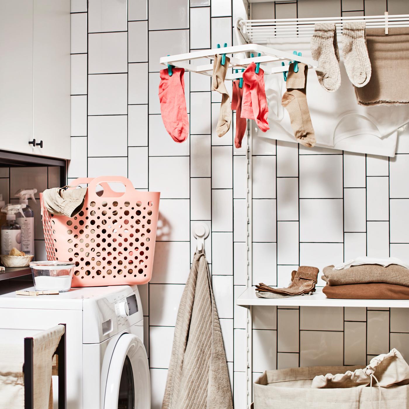 A bathroom with a washing machine, a storage combination for laundry with a cabinet, plus a laundry combination with a shelf.
