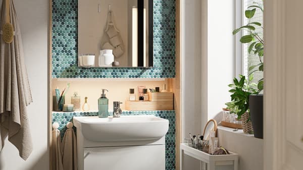 A bathroom with small blue tiles and white fixtures.