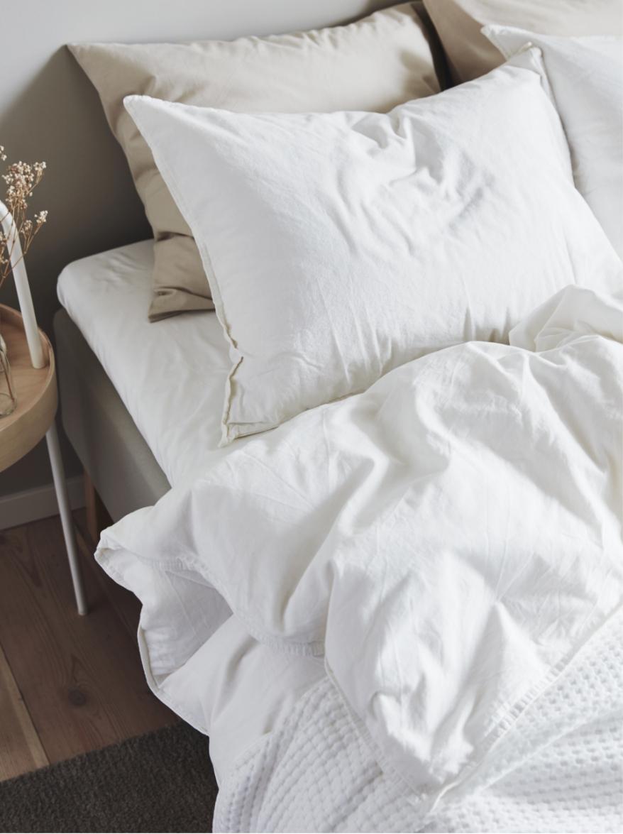 A bed with several pillows and blanket on it.