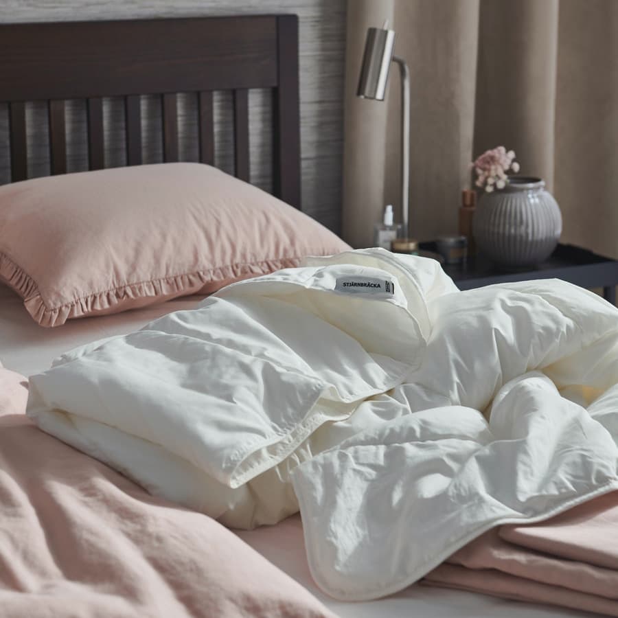 A bed with STJÄRNBRÄCKA Warm duvet on it. 