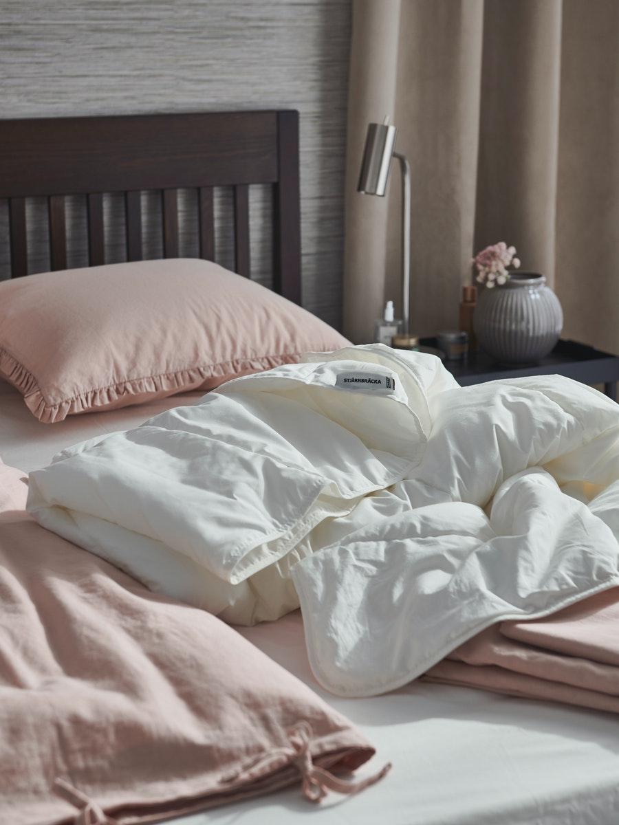 A bed with STJÄRNBRÄCKA Warm duvet on it.